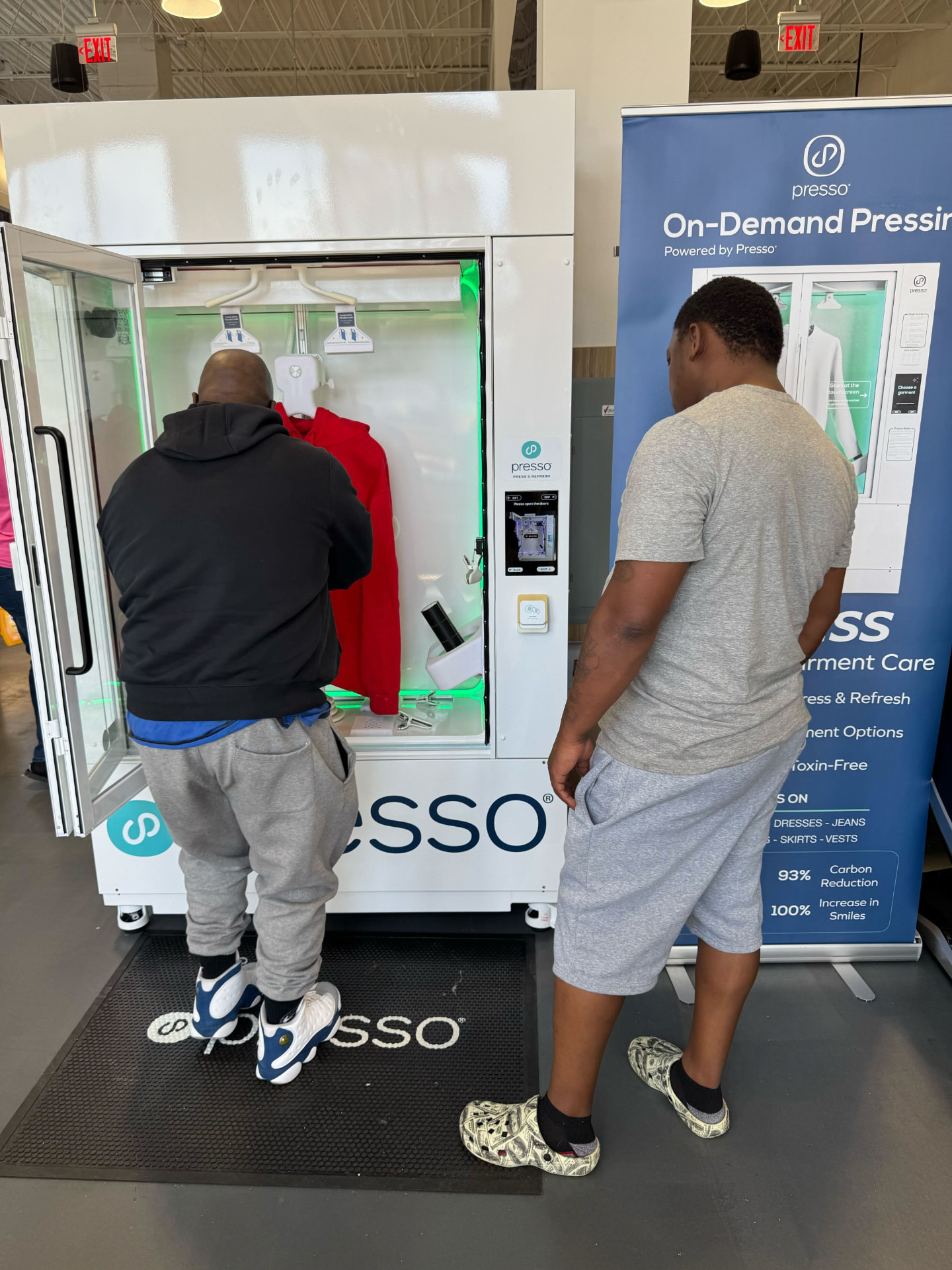 A customer loading a garment into the Presso press at Oz Laundry
