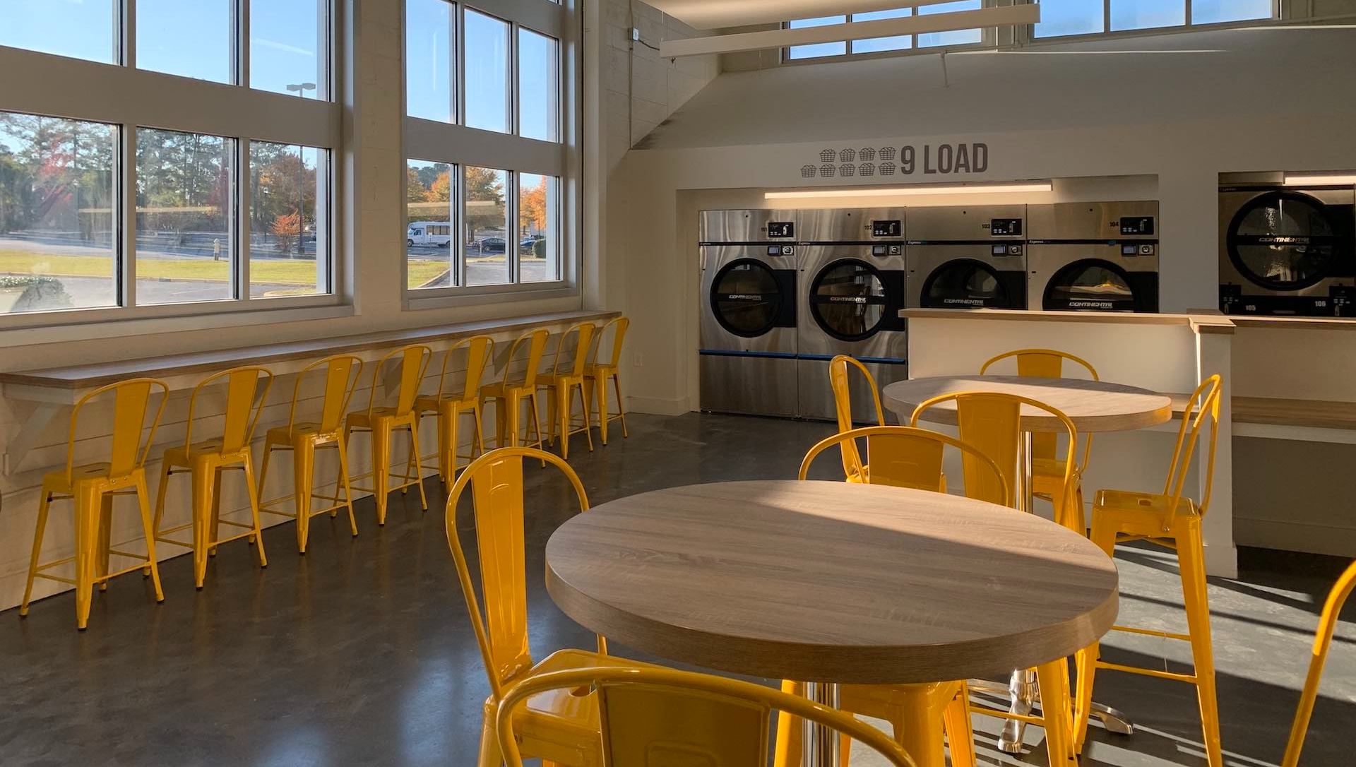 The bright interior of Oz Laundry in Decatur with washers and seating stools